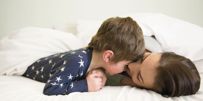 A mother and her young son laying on a bed