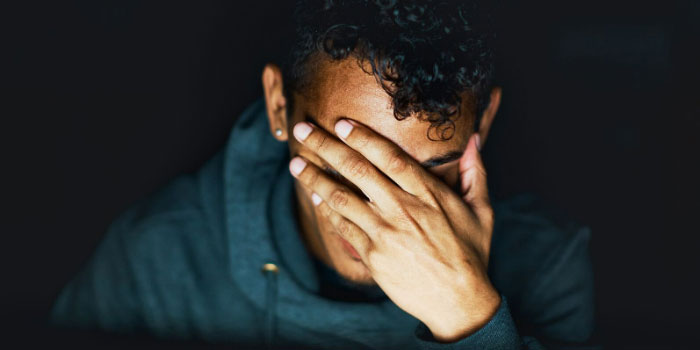 person rubbing their eyes looking worried