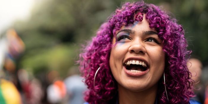 person smiling at a pride parade
