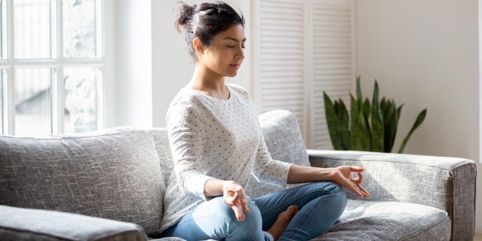 woman meditating on sofa
