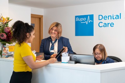 Patient speaking to reception team at dentist